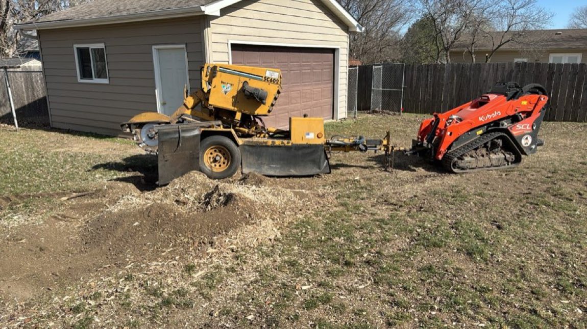 McCune Tree Service stump grinder and compact loader on a backyard stump-grinding job