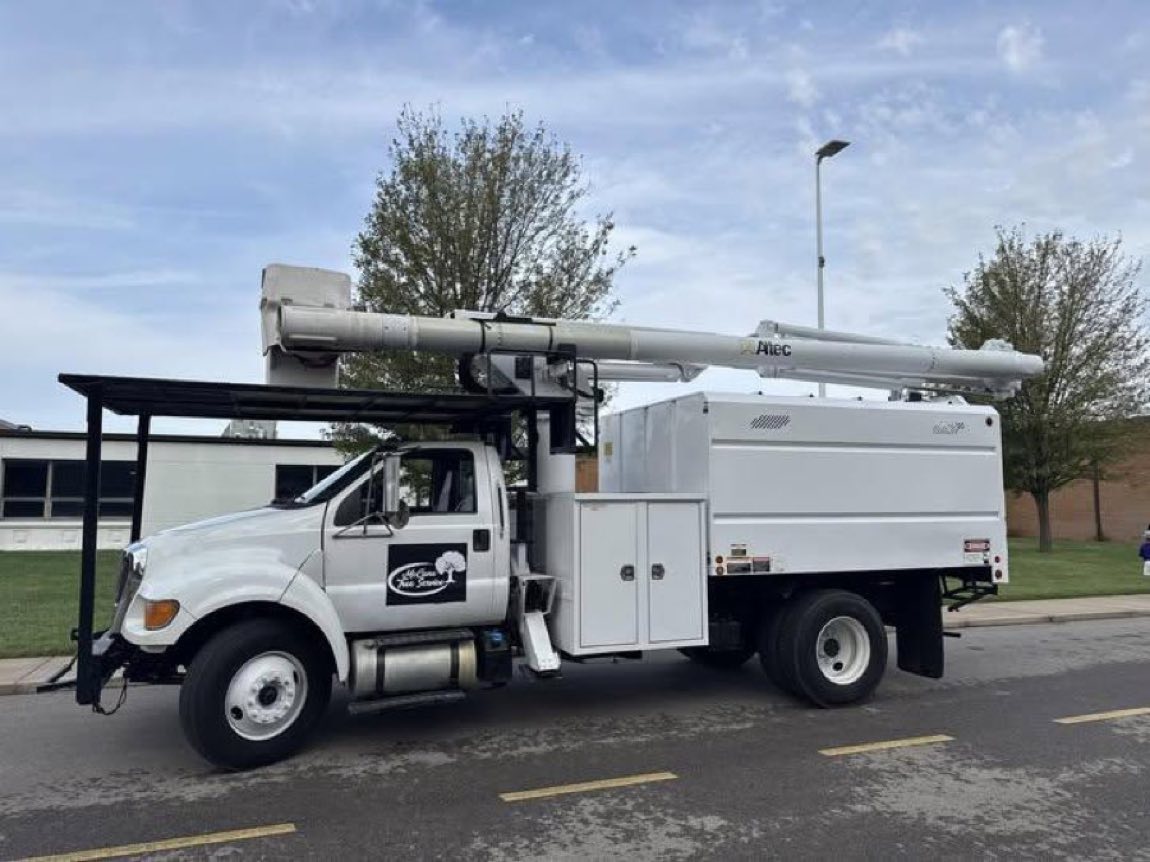 McCune Tree Service branded bucket and chipper truck